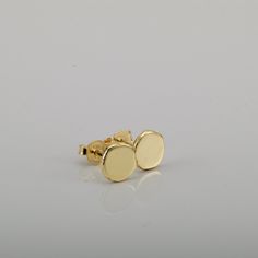 "Shiny round gold 14k stud earrings, simple and perfect for every day's wear.   These gold earrings are handmade of yellow 14k solid gold.  I melted the gold into a ball, and then hammered each ball to its irregular shape. No two are ever identical, and each has a unique and organic look. The edges of the pebbles are rough, while the flat surface has a smooth shiny finish. These are classic \"wear with everything\" gold stud earrings - a perfect gift, or a treat for yourself. Earrings diameter is approx. 7 mm = ~0.27 inch, and they are 1.2 mm thick. 14k solid gold ear backs are included. * The earrings will be packed in a gift box ready to give as a gift, and shipped via Express mail service which usually takes 4-6 business days to arrive. * To see similar earrings in a slightly smaller si Dainty Yellow Gold Circular Earrings, Minimalist Round Earrings With Polished Finish, Minimalist Polished Round Earrings, Polished Recycled Gold Round Earrings, Dainty Round Earrings With Polished Finish, Yellow Gold Simple Earrings, 14k Yellow Gold Circle Earrings, Hypoallergenic Round Earrings In Recycled Gold, Yellow Gold Round Disc Earrings For Everyday