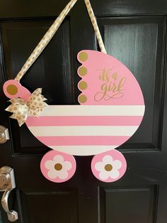 a door hanger with a pink baby carriage on it