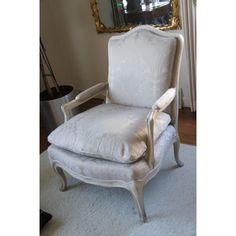 a white chair sitting in front of a mirror on top of a carpeted floor