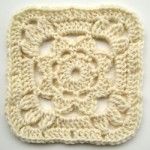 a crocheted square with an intricate design on the center is shown in white