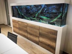 a fish tank mounted to the side of a wall next to a dining room table