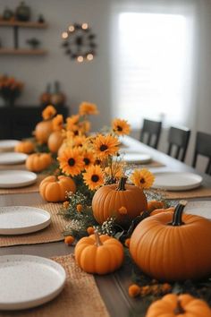 the table is set with pumpkins and sunflowers