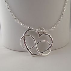 "Stunning Hand Crafted Solid Silver 925 Infinity Heart Pendant This stunning and unusual pendant is handmade by Little Bird Studio 22 and is hand crafted from solid sterling silver 925. The pendant is beautifully inspired and combines a heart..the symbol of love with infinity. It is approx. 25mmx25mm The design is beautiful in its simplicity. I have other unique jewellery available so please check out my other items This on trend pendant would make a gorgeous gift or beautiful treat for yourself The design is truly unique and the pendant comes complete with an 18\" solid sterling silver chain, it will also come with a lovely handmade unbleached cotton gift pouch. Please feel free to ask any questions you may have and I will do my best to answer as swiftly as possible. I will happily make p Sterling Silver Heart Necklace With Round Pendant For Anniversary, Symbolic Sterling Silver Jewelry For Valentine's Day, Silver Engraved Infinity Necklace, Sterling Silver Infinity Necklace Engraved, Sterling Silver Infinity Heart Necklace For Anniversary, Infinity Sterling Silver Engraved Necklace, Engraved Sterling Silver Infinity Necklace, Silver Infinity Heart Necklace For Anniversary, Silver Heart Pendant Jewelry