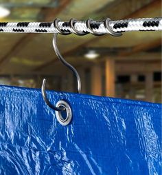 a blue tarp with metal hooks hanging from it