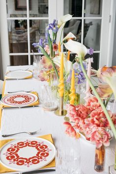 the table is set with flowers and plates