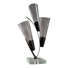 two black and clear glass vases sitting on top of a metal stand