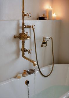 an old fashioned bathtub with water running from the faucet and shower head