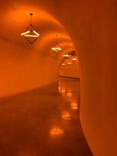 an orange tunnel with lights hanging from the ceiling