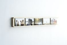 a white wall with four pictures hanging on it