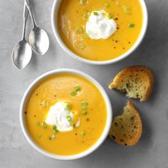 two bowls of soup with bread and sour cream