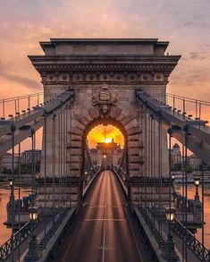 an image of a bridge with the sun going down