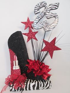 a zebra print bag with red and silver stars on it next to a pair of high heeled shoes