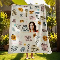 a woman is holding up a blanket with words on it