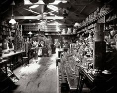 an old time store with many items on the shelves and people standing in front of it