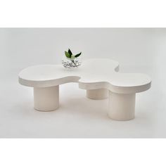 a white table with two benches and a flower vase on the top, in front of a white background