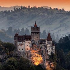 an old castle sits on top of a mountain