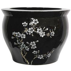 a black vase with white flowers painted on it