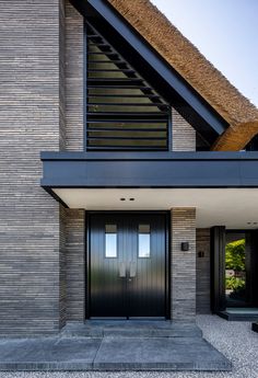 the front entrance to a modern house with black doors