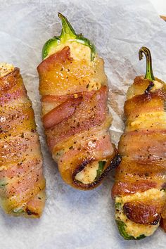 bacon wrapped jalapenos sitting on top of wax paper next to each other