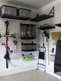 a garage with several storage bins on the wall and various tools hanging from the ceiling