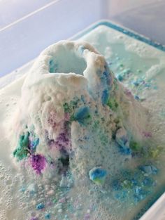 an ice cream cake with sprinkles and blue, green, purple, and white icing