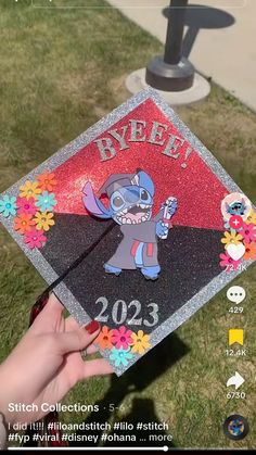 someone is holding up a graduation cap that has stitched images on the front and side