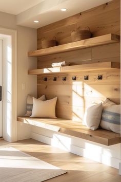 a room with wooden shelves and pillows on top of the shelf, next to a white door