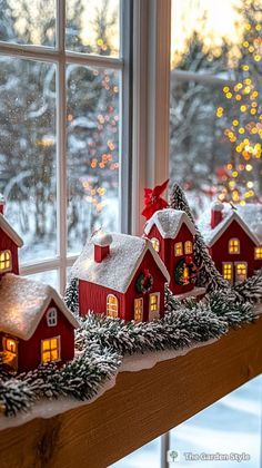 a window sill decorated with christmas decorations and lights in front of a snowy scene