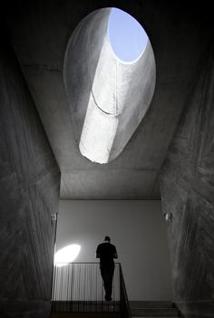 a man is standing in the middle of a stairwell with his back to the camera