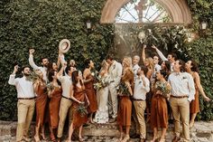 a group of people standing next to each other in front of a wall covered with ivy