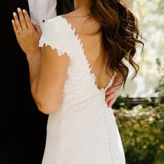 the bride and groom are standing close together