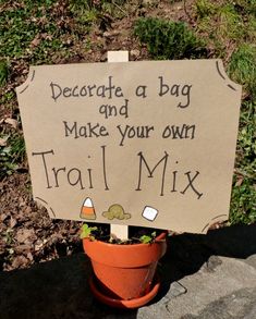 a sign that says decorate a bag and make your own trail mix in a flower pot