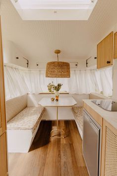 the inside of a camper with wood flooring and white walls