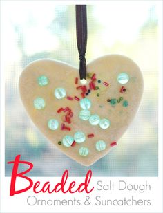 a heart shaped ornament hanging from a string on a window sill with the words beaded salt dough ornaments and sun catchers