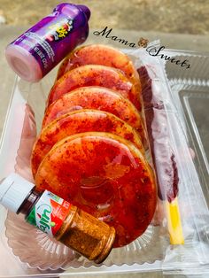 a plastic container filled with sliced up meat and condiments next to a bottle of ketchup