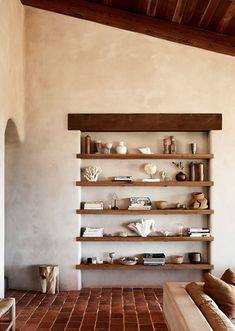 a living room filled with lots of furniture and shelves on the wall next to each other