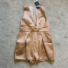 New With Tags. Originally 105$. Champagne Colored Romper From Topshop. A-Line Shape. Deep V Neckline In The Front. Zipper In The Back. Had Minor Imperfections With The Stitching On The Pleats In The Back As Shown But Barely Visible. Waist Measures 15 Inches. Length Measures 27 Inches. Size 6 Petite. Beige Jumpsuit For Night Out, Beige V-neck Jumpsuits And Rompers For Night Out, Spring Party Jumpsuits And Rompers In Beige, Spring Party Beige Jumpsuits And Rompers, Party V-neck Jumpsuit With Pockets, Gold Jumpsuits And Rompers For Spring, Sleeveless Gold Jumpsuits For Spring, Boho Playsuit, Pinstripe Jumpsuit