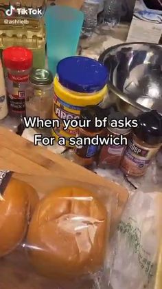 two bagels sitting on top of a wooden cutting board next to other food items