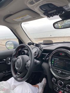 a person sitting in the driver's seat of a car with their feet on the steering wheel