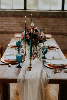 the table is set with candles and plates