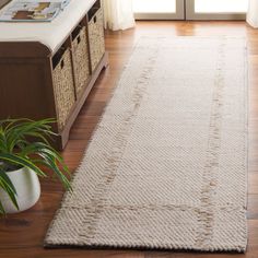 a living room with a large white rug on the floor