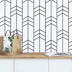 a bag sitting on top of a wooden table next to a wall with black and white lines