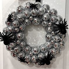 a silver and black christmas ornament hanging on a door with spider webs