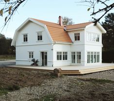 a large white house sitting on top of a dirt field