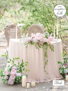 a table with flowers and candles is set up in the middle of a forest for a wedding reception