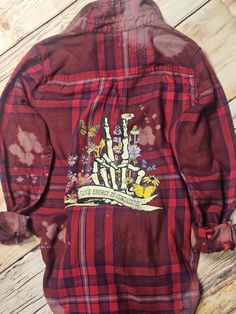 a red and black plaid jacket with an image of a castle on the back,