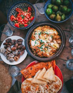 a table topped with plates and bowls filled with food