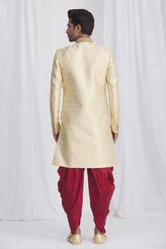 Gold sherwani in jacquard silk brocade base fabric featuring floral motifs and embellished button details. Paired with contrast dhoti pant.
Component: 2
Neckline: Mandarin
Sleeve Length: Full
Fabric: Sherwani: Jacquard Silk Brocade; Dhoti: Dupion Art Silk; Lining: Faux Satin
Color: Gold
Front overlap panel
Embellished button details
Elasticated and drawstring waistband
Note: The pocket square worn by the model is for styling purpose only - Aza Fashions Elegant Jacquard Traditional Wear For Festive Occasions, Gold Brocade Kurta For Reception, Festive Traditional Jacquard Wear With Zari Work, Festive Jacquard Traditional Wear With Zari Work, Traditional Ceremonial Sherwani With Zari Weaving, Gold Brocade Nehru Jacket With Traditional Drape, Brocade Kurta With Traditional Drape For Reception, Gold Banarasi Silk Sherwani With Zari Work, Gold Art Silk Sherwani With Traditional Drape