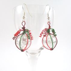 These lovely earrings are made from sparkly fried marbles wrapped in dark red green and red wire, and dangle from silver fishhook ear wires. Beautiful statement piece - great as a gift or for yourself! The cracks inside the iridescent marbles sparkle and catch the light beautifully. I fried the marbles myself and then wrapped in wire - I really enjoy the process and the final product, I hope you will too! From the top of the fish hook ear wire to the the bottom of the marble is 1.75", wire wrapp Holiday Red Ear Wire Earrings, Red Holiday Earrings With Ear Wire, Red Ear Wire Earrings For Holiday, Red Copper Wire Jewelry Gift, Green Copper Wire Earrings Gift, Red Wire Wrapped Earrings For Party, Green Wrap Earrings For Gift, Sparkly Christmas, Marble Earrings