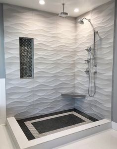 a bathroom with a walk in shower next to a tiled floor and white tile walls